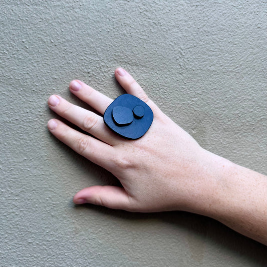 A woman's hand wears a black ring made of rubber