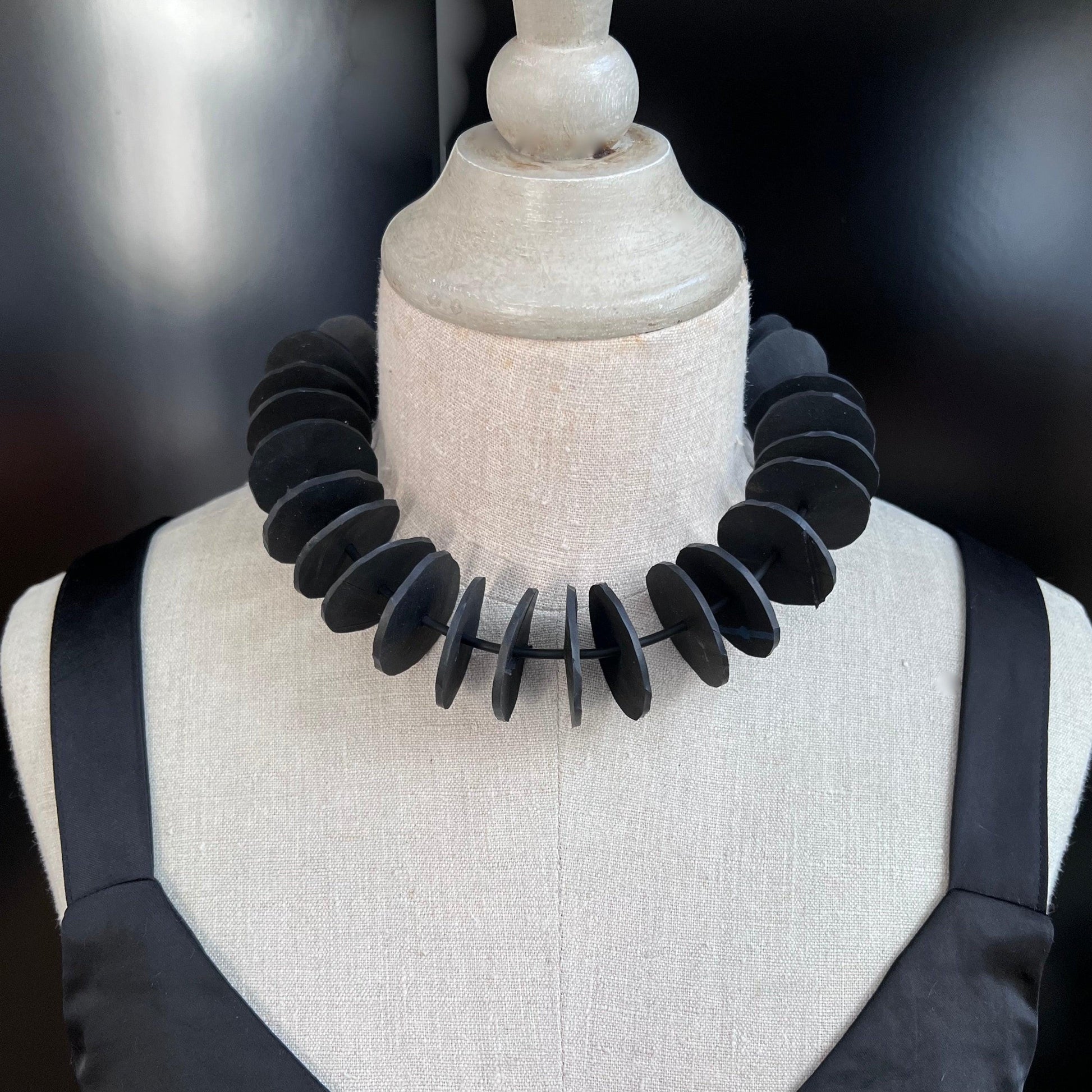 A mannequin wears a necklace with small circles in a choker style