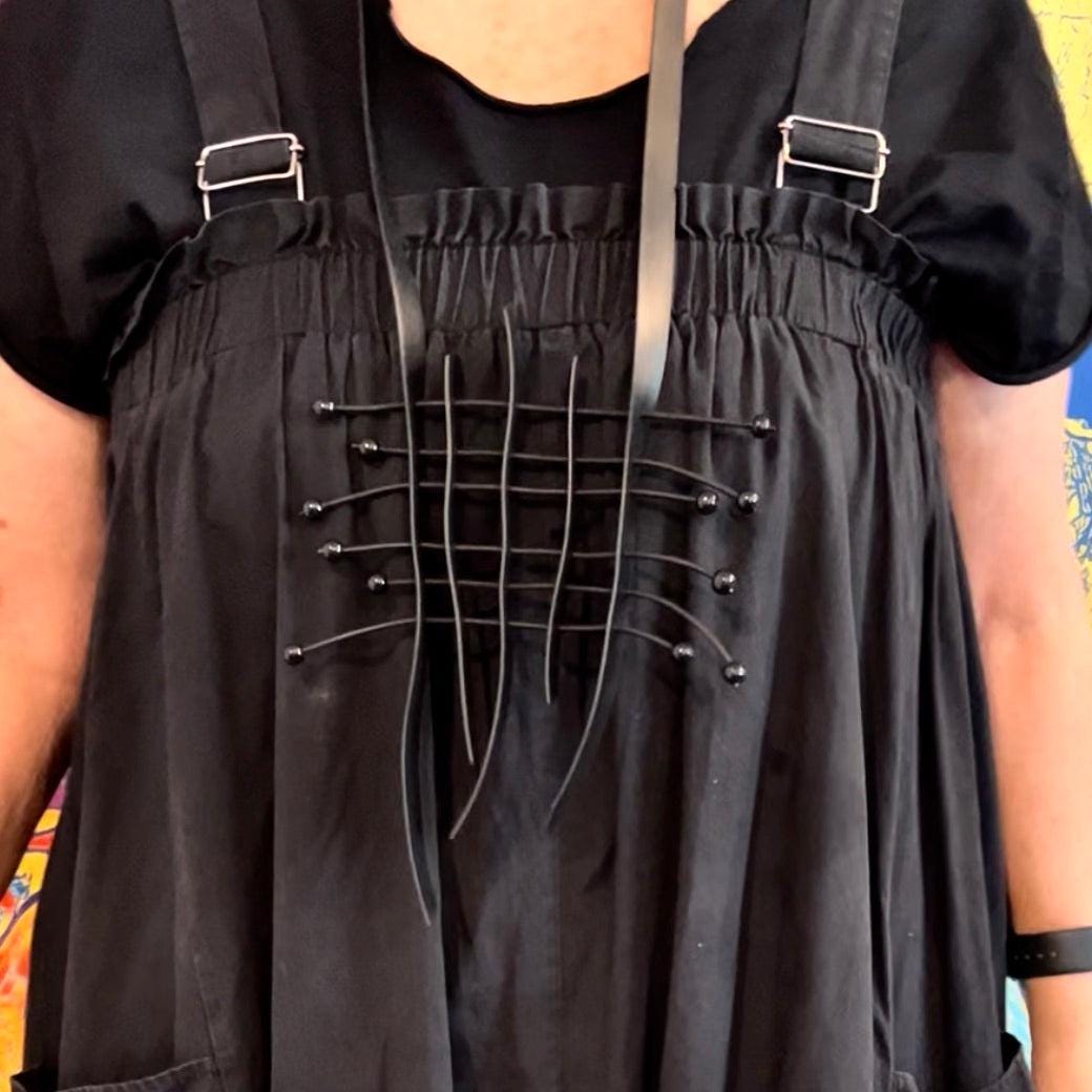 A model wears a grid style rubber necklace