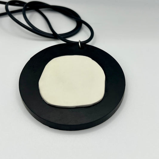 A repurposed rubber black and white pendant necklace