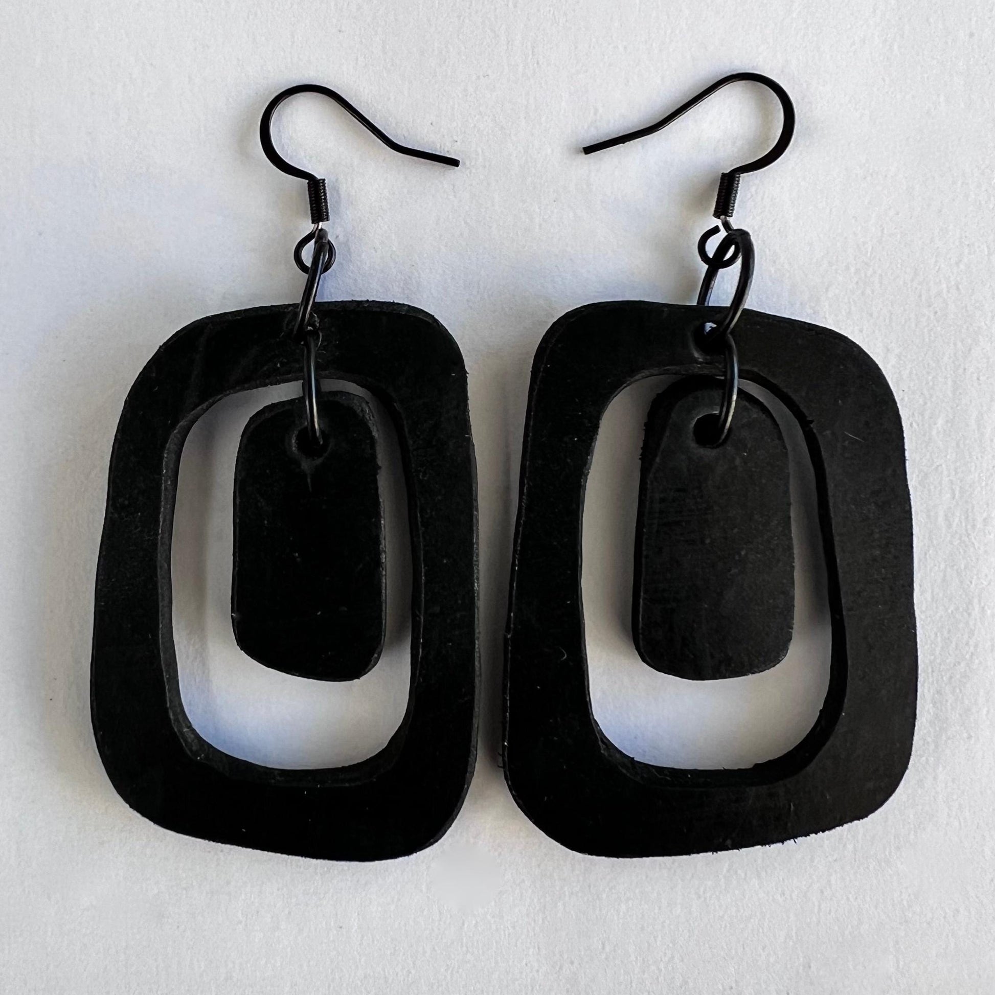 A pair of black earrings in a mid century style shape