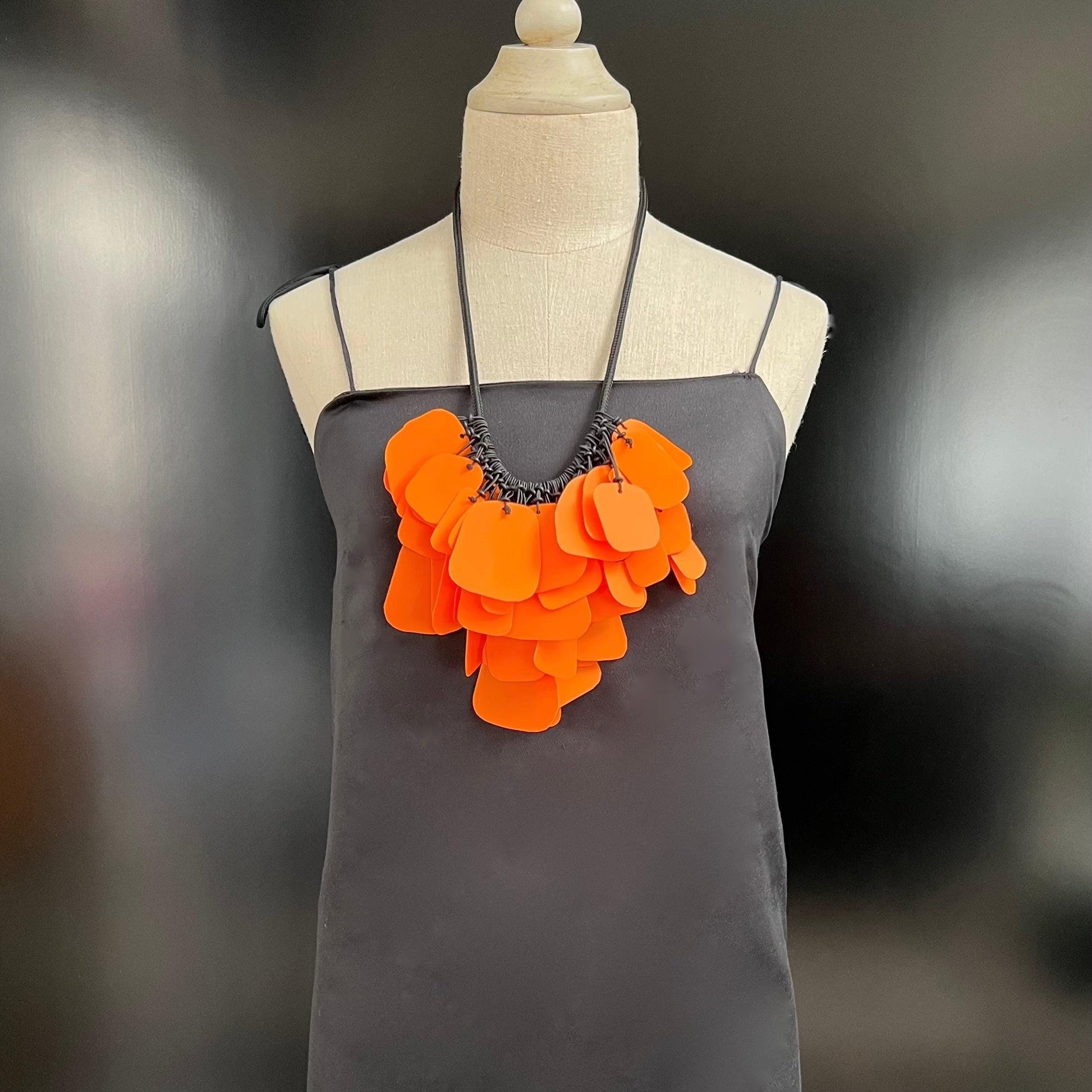 A mannequin wears a bright orange necklace