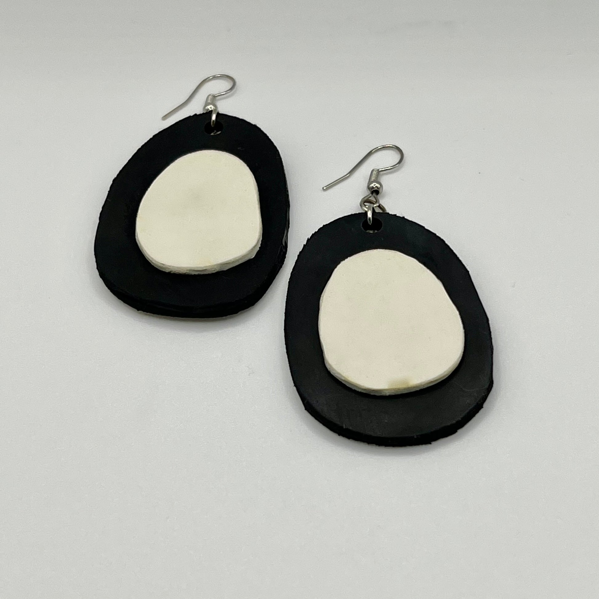 A pair of black and white egg shaped dangle earrings
