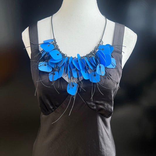 A mannequin wears an bright blue recycled plastic necklace