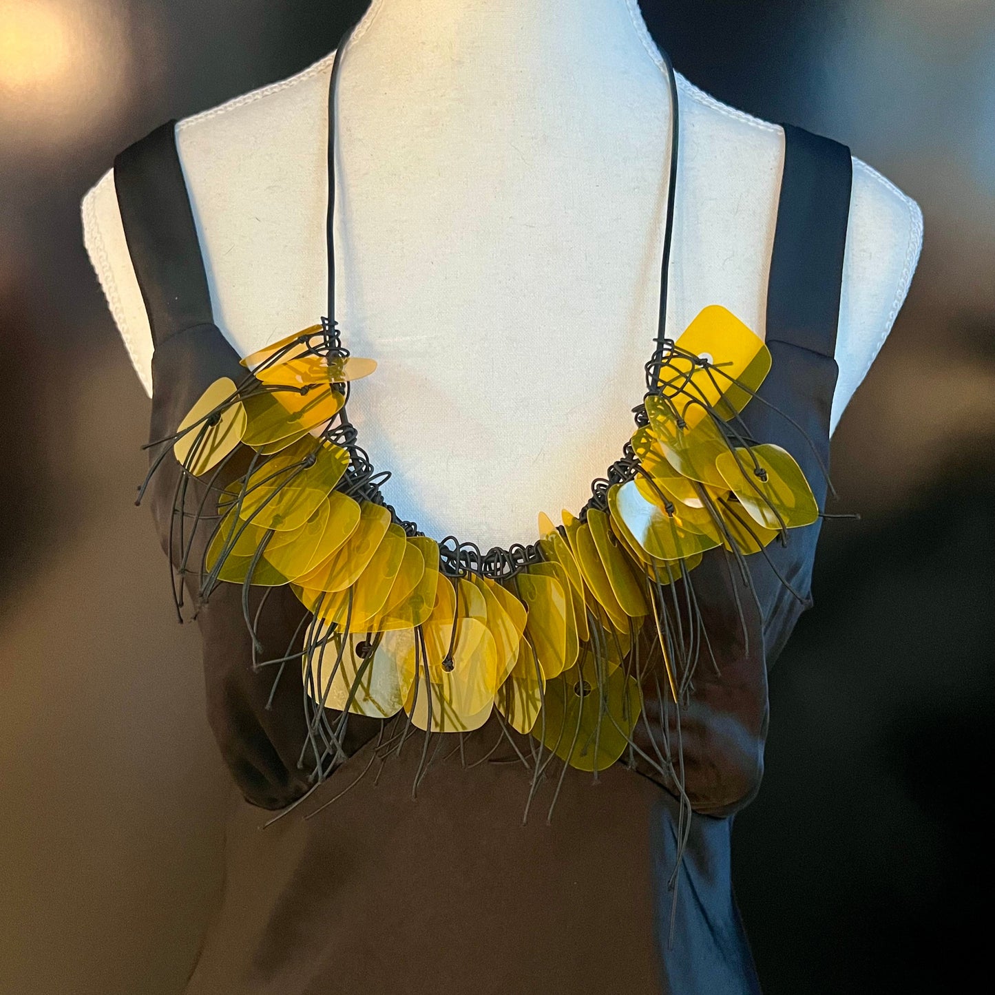 A mannequin wears a gold plastic necklace
