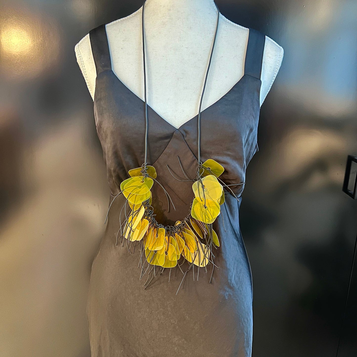 A mannequin wears a gold plastic necklace