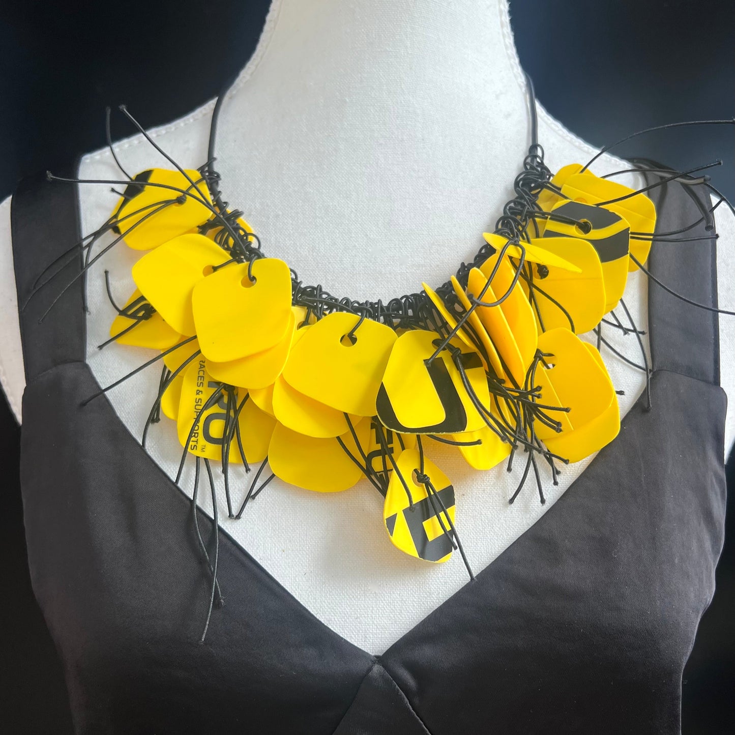 A mannequin wears a yellow and black necklace