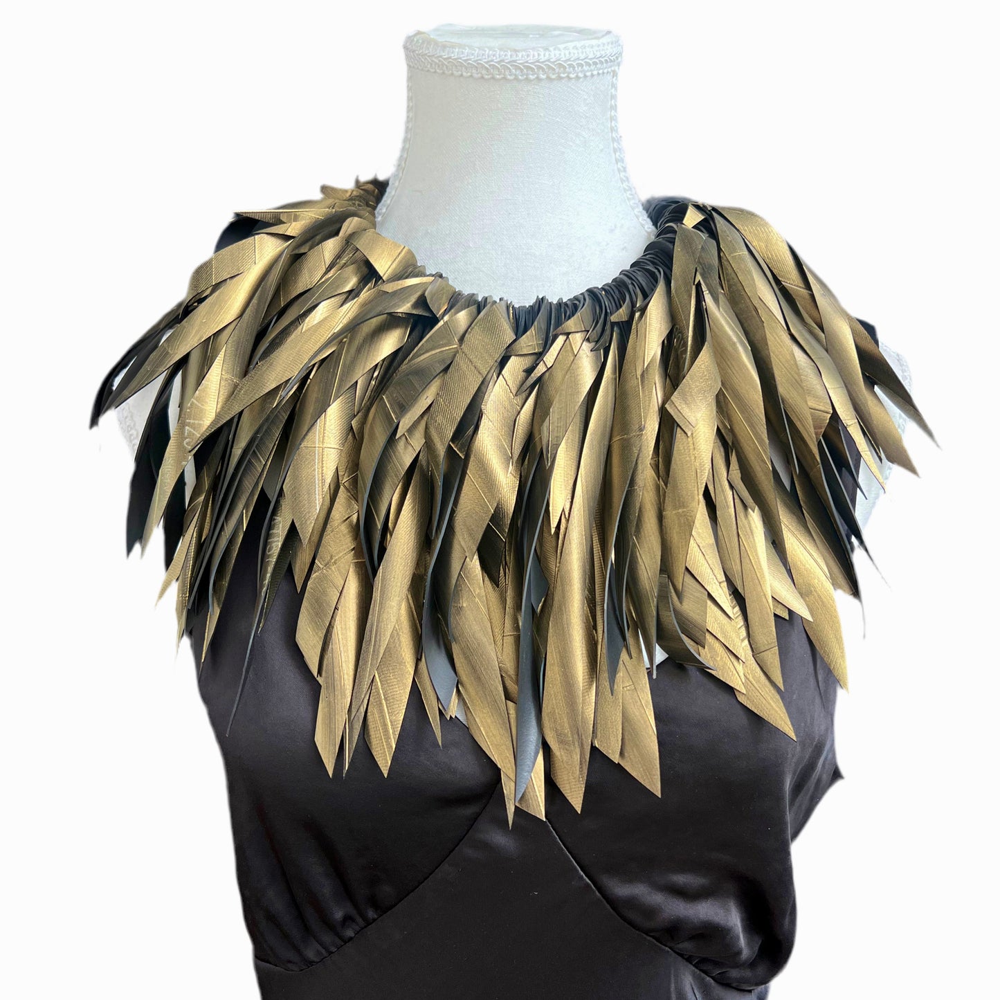 Gold feathery necklace collar on a mannequin against a white background
