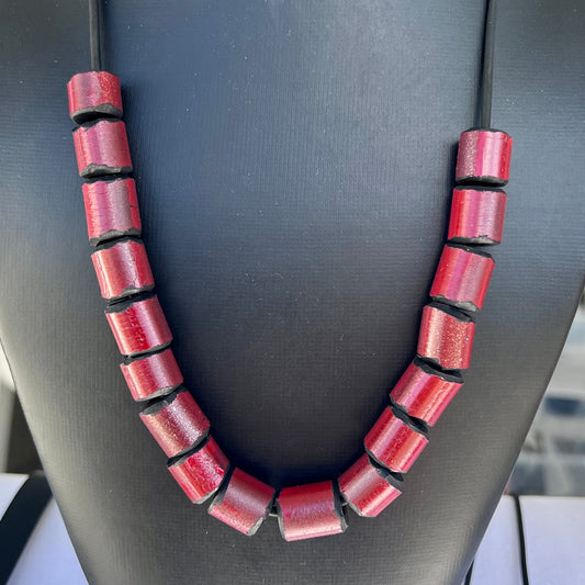 A mannequin wears a red bead necklace