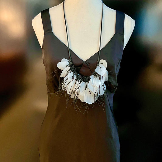 A mannequin wears a white recycled plastic necklace
