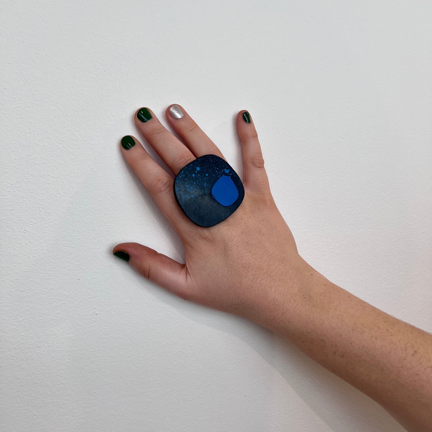 A woman's hand wearing a large blue rubber ring