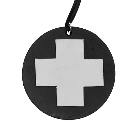 A black rubber round pendant on a necklace. A white cross sits inside the round pendant