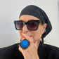 A woman wears a long slouchy black hat.