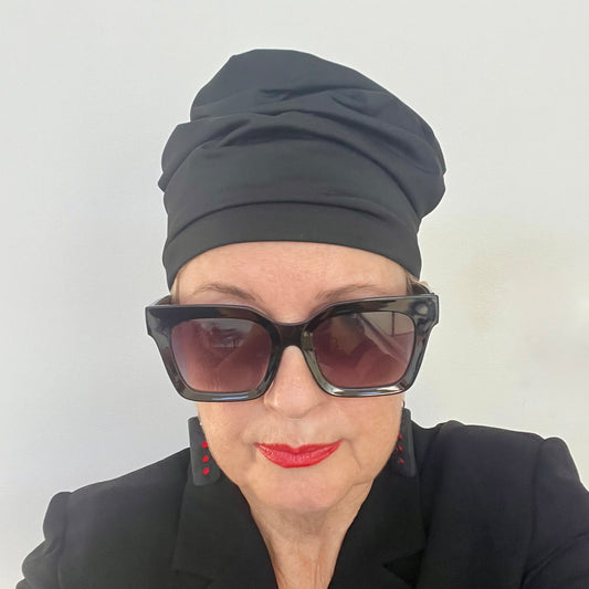 A woman wears a black soft hat