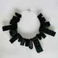 A large rectangular shaped choker of black rubber
