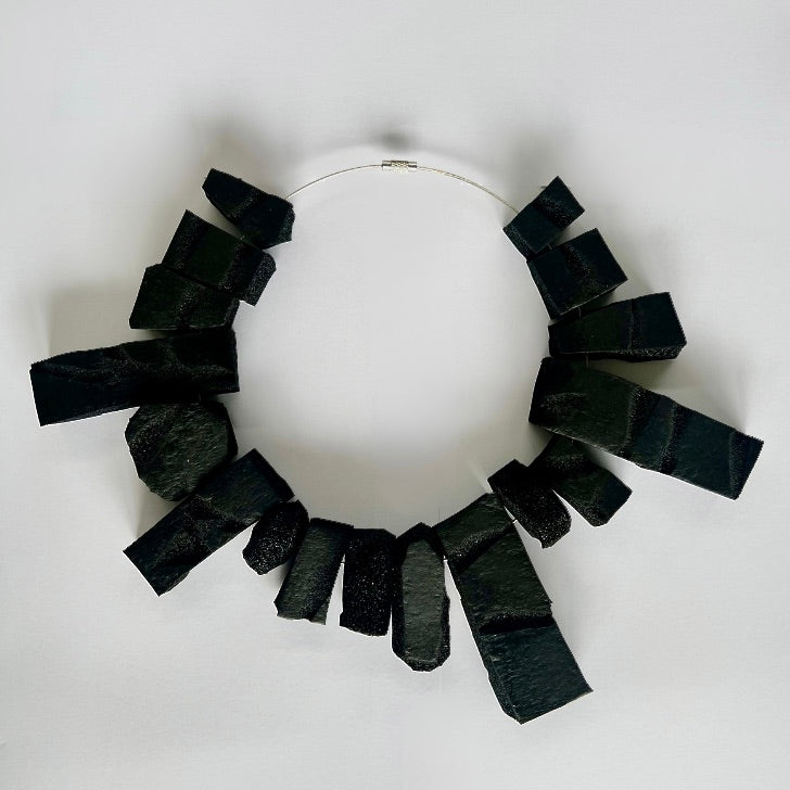 A large rectangular shaped choker of black rubber
