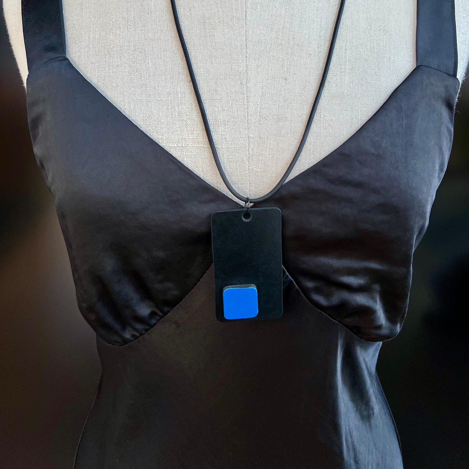 A mannequin wears and black and blue necklace