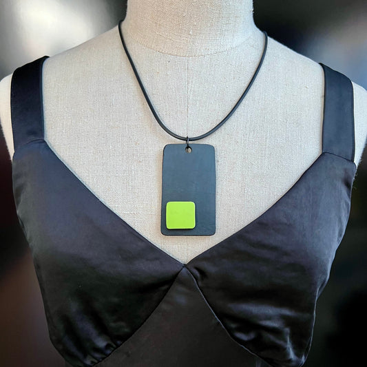 A mannequin wears and black and green necklace