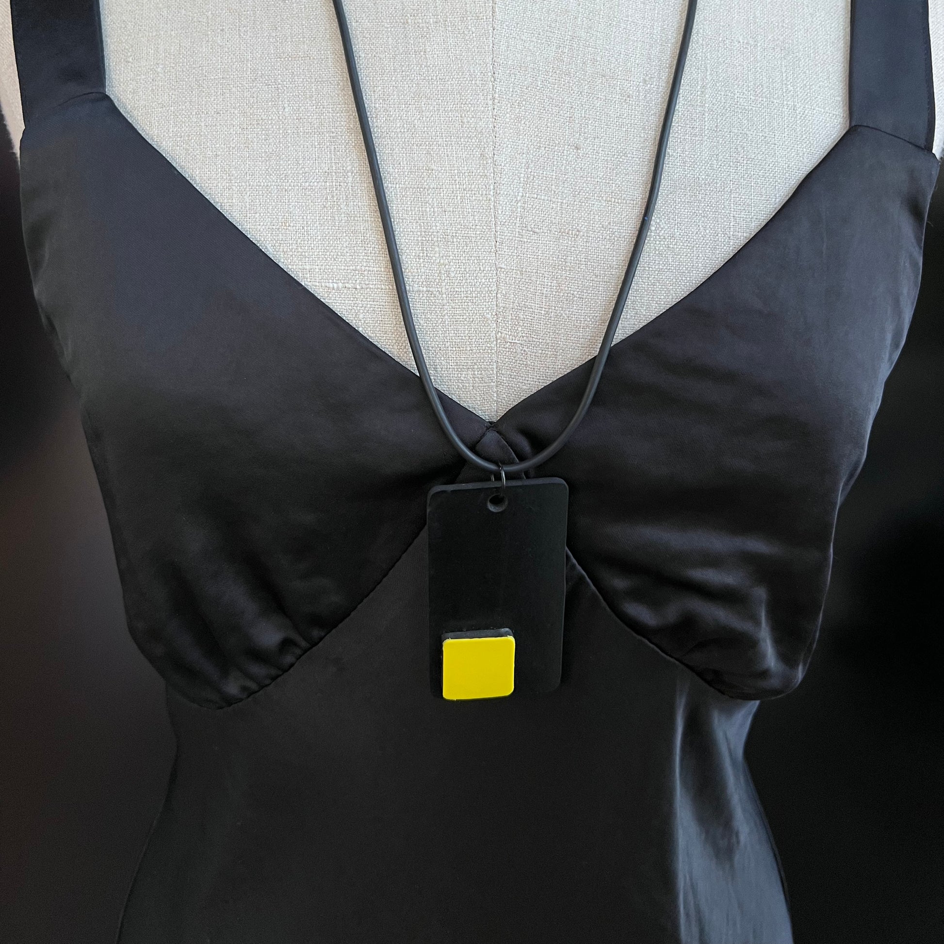 A mannequin wears and black and yellow necklace