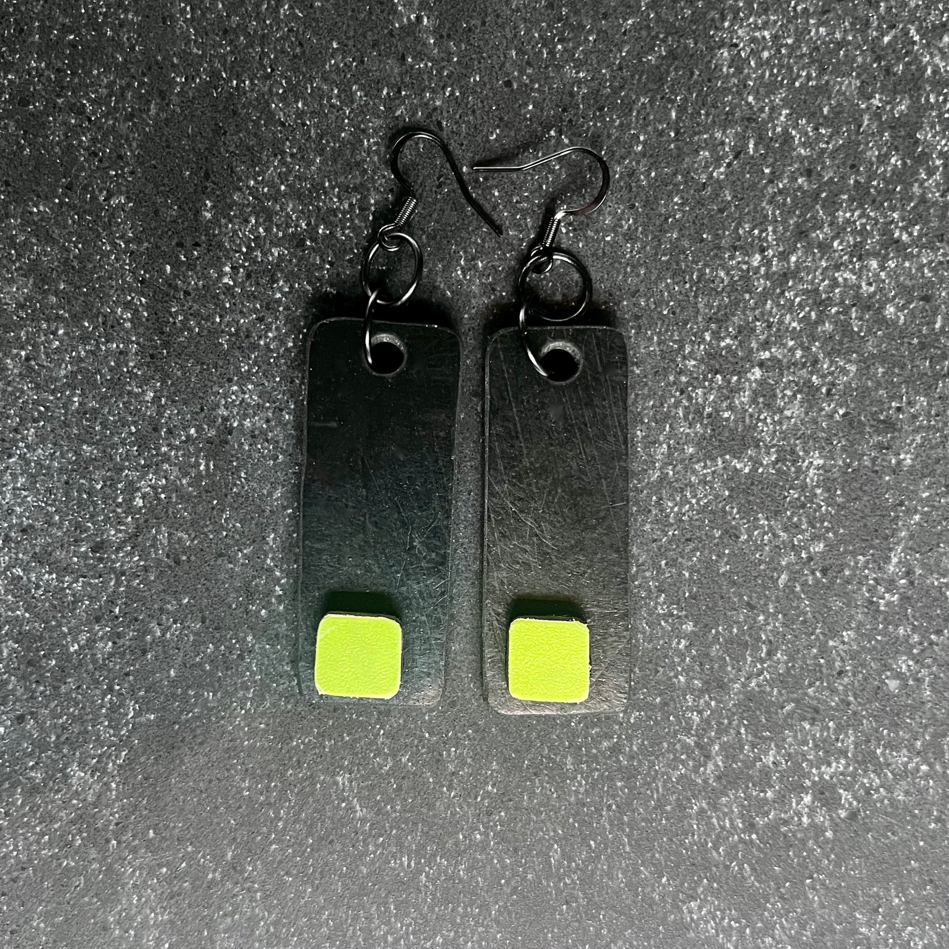 A pair of black and green earrings