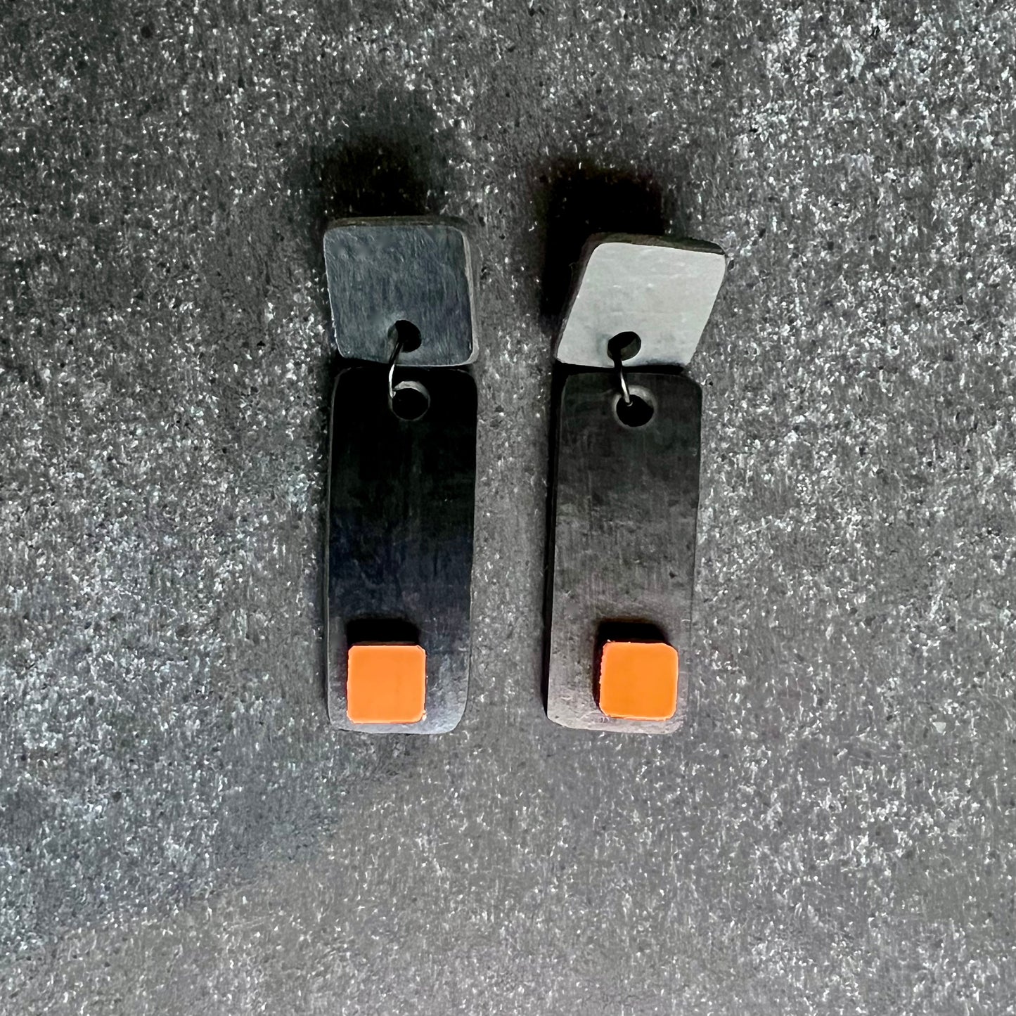 A pair of black and orange sixties styled earrings
