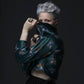 A model strikes a pose wearing two large square bronze chunky rings