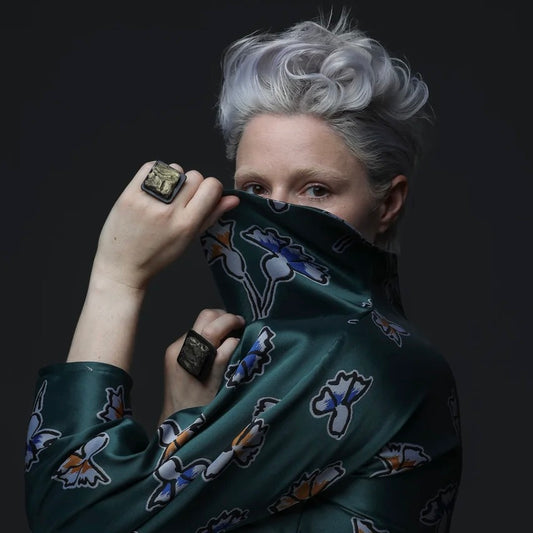 A model wears two bronze square rings