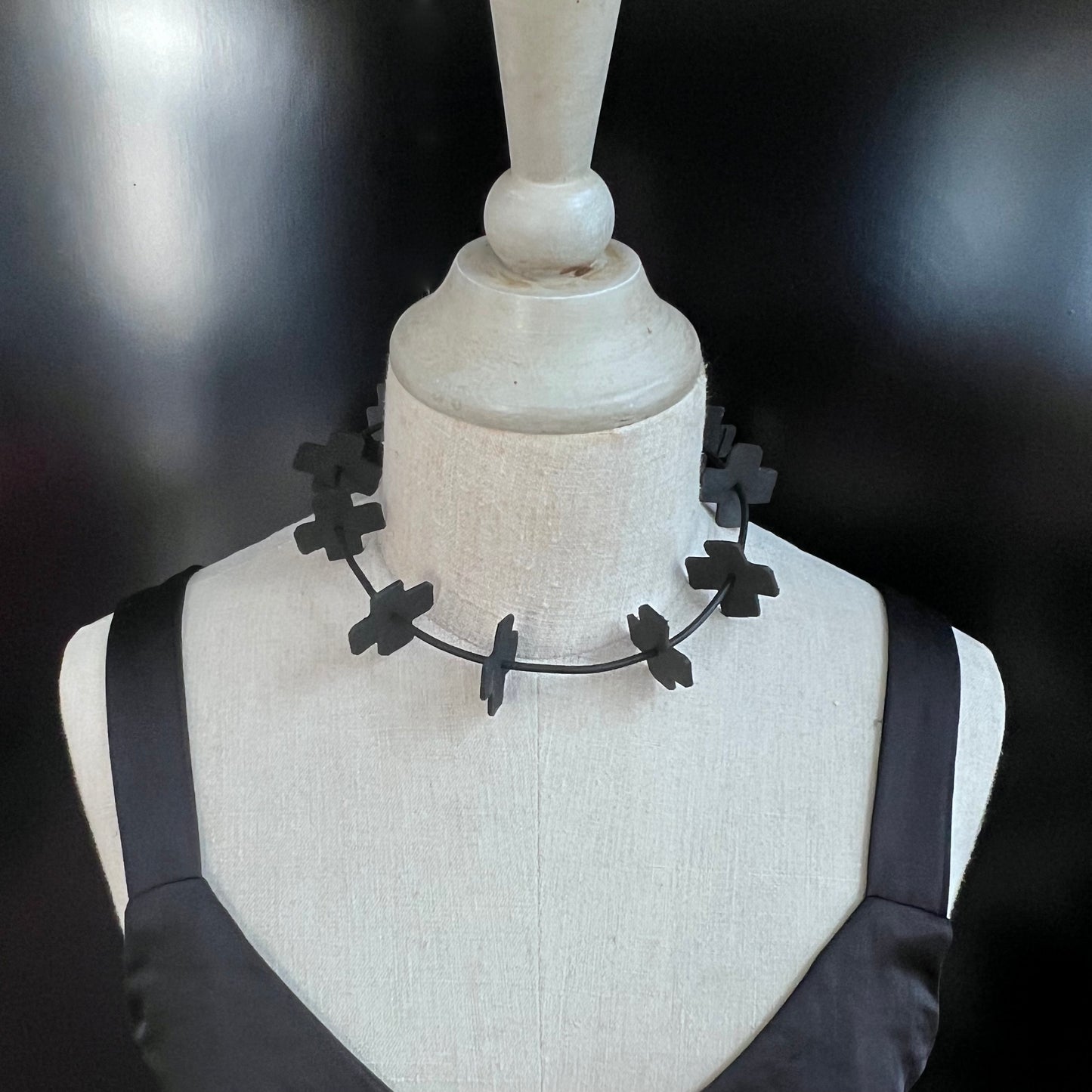 A mannequin wears a choker of small rubber crosses