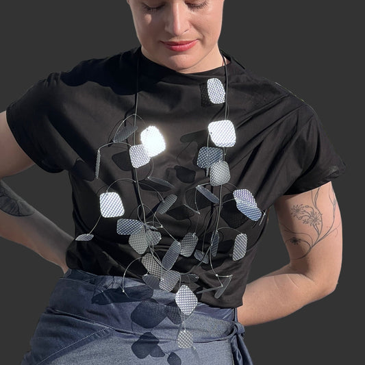 A model wears a silver glistening necklace in the sunshine