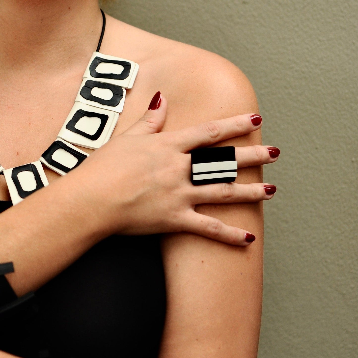 A woman wears a black rubber ring which features GT stripes