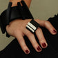 A woman wears a black rubber ring which features GT stripes