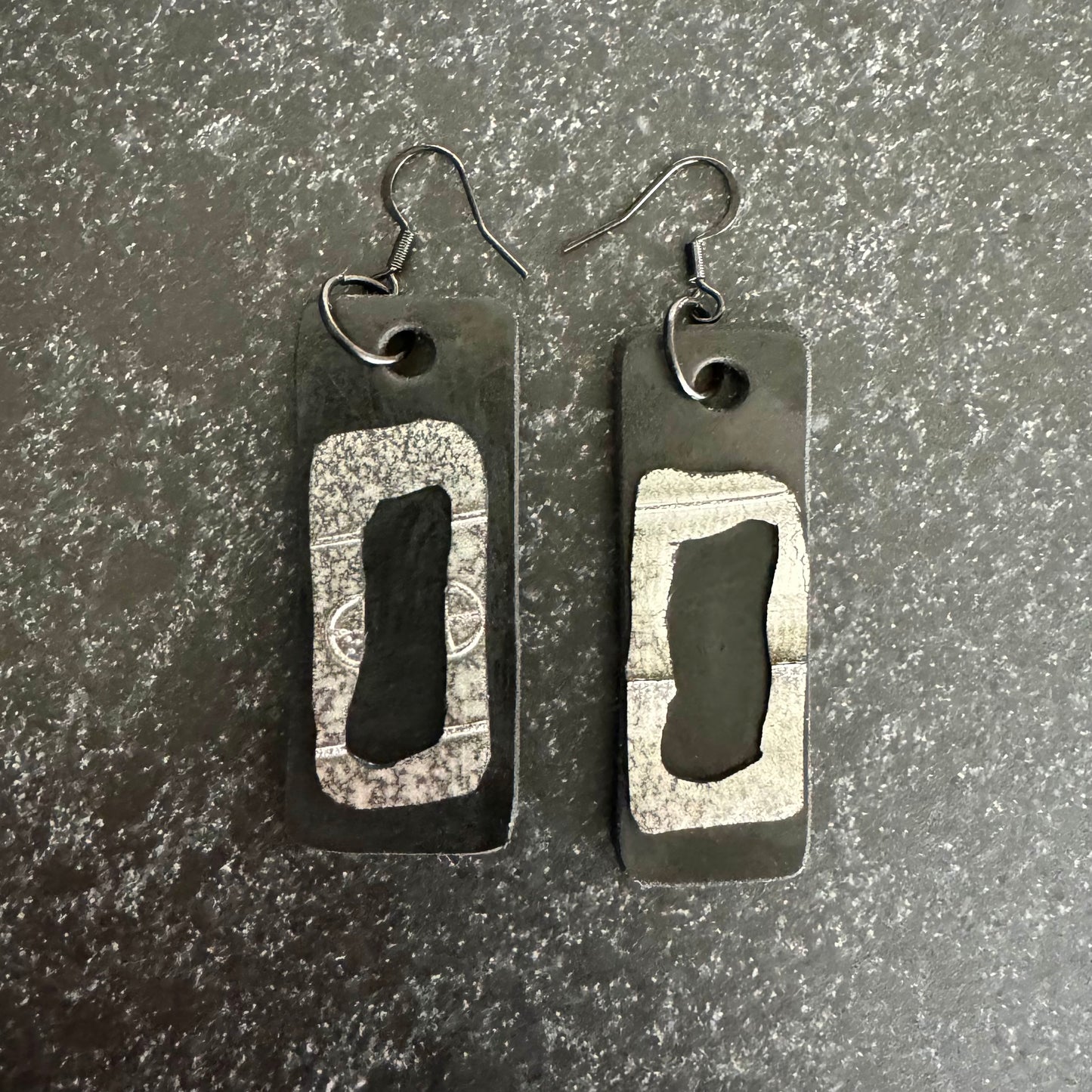 A pair of black and painted silver rubber earrings