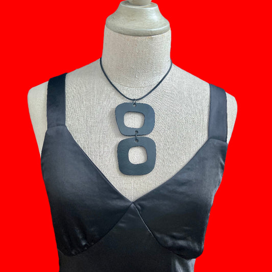 A mannequin wears a short necklace made from rubber