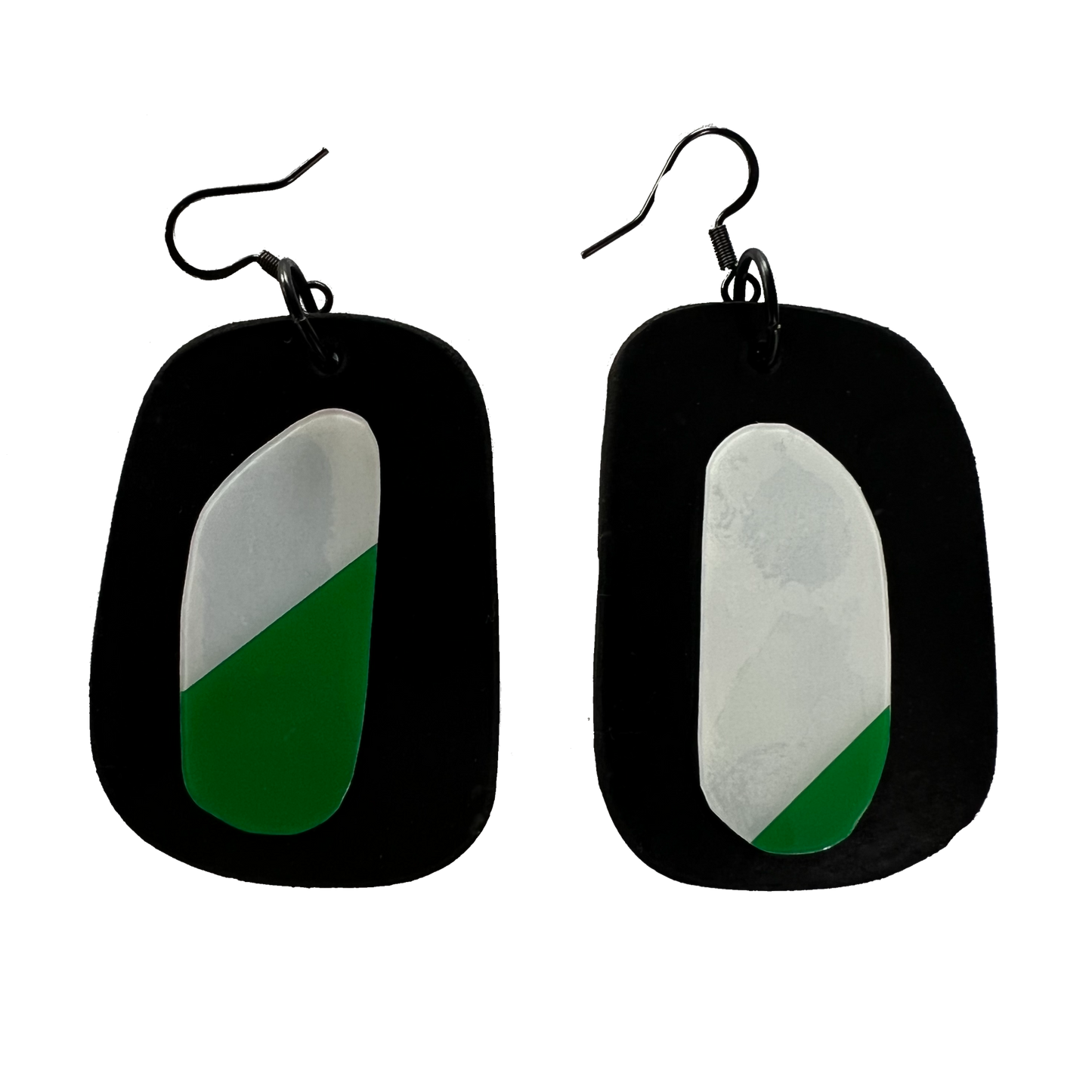 A pair of earrings made up of rubber discs topped with discs cut from a repurposed exit sign