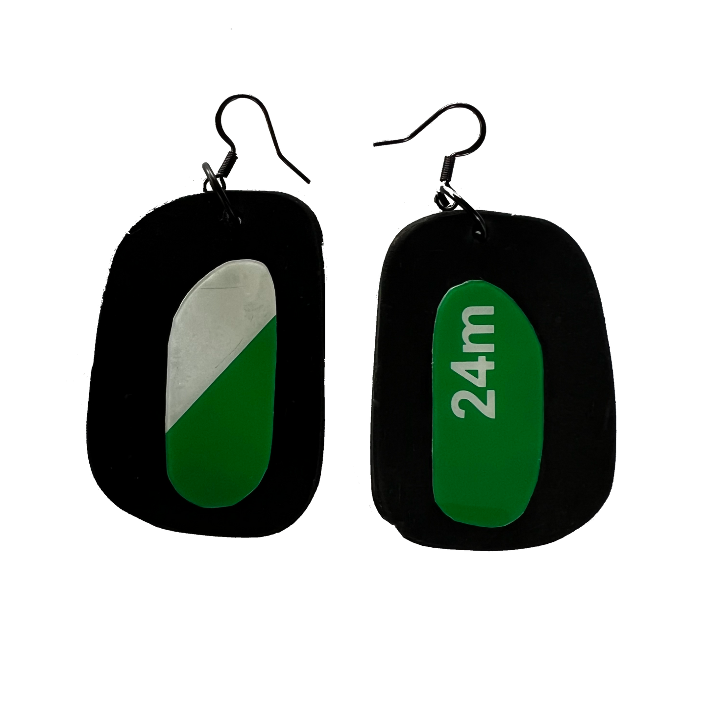 A pair of earrings with discs of rubber topped by discs of an ex exit sign plastic