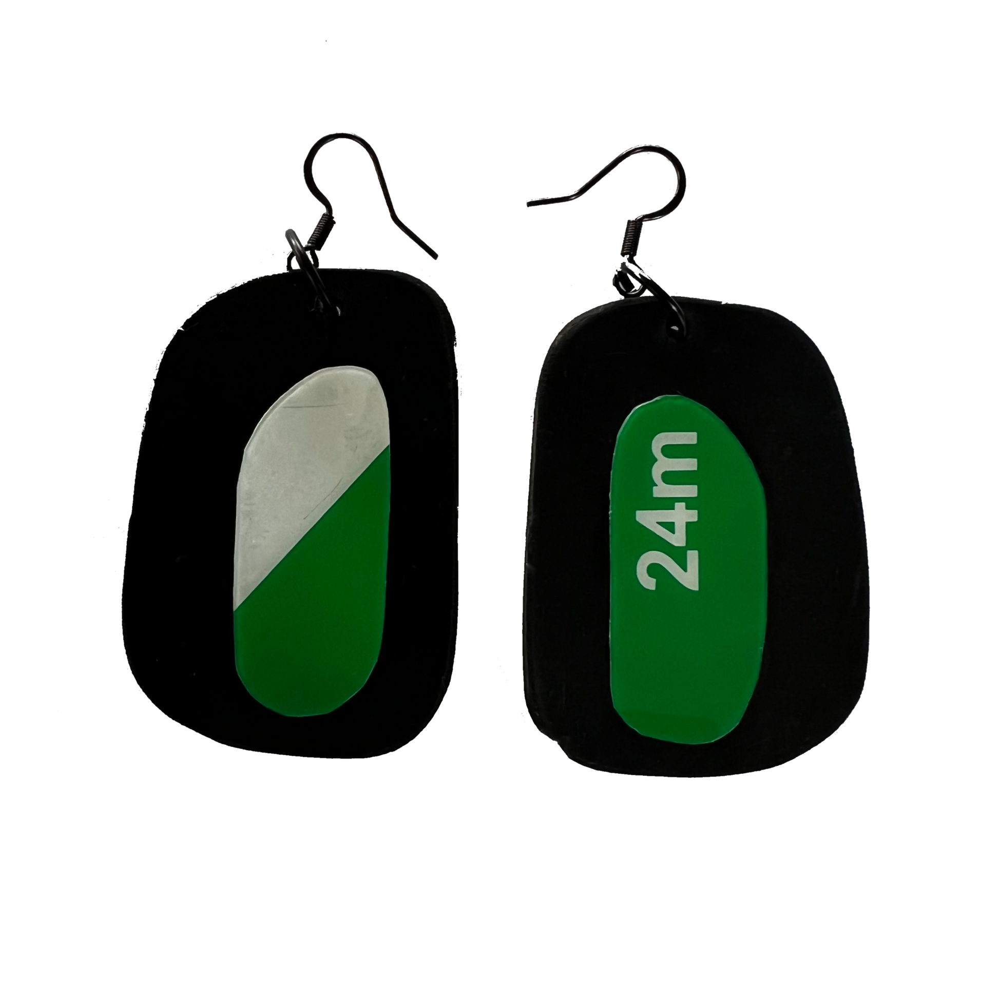 A pair of earrings with discs of rubber topped by discs of an ex exit sign plastic