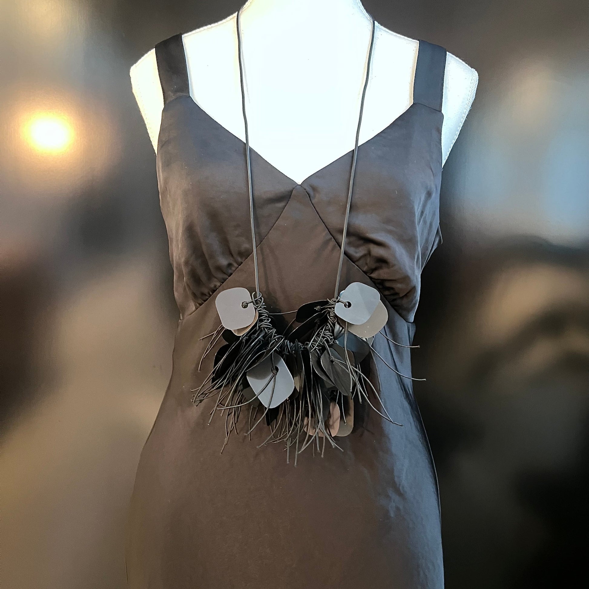 A mannequin wears a black plastic necklace made from x-rays