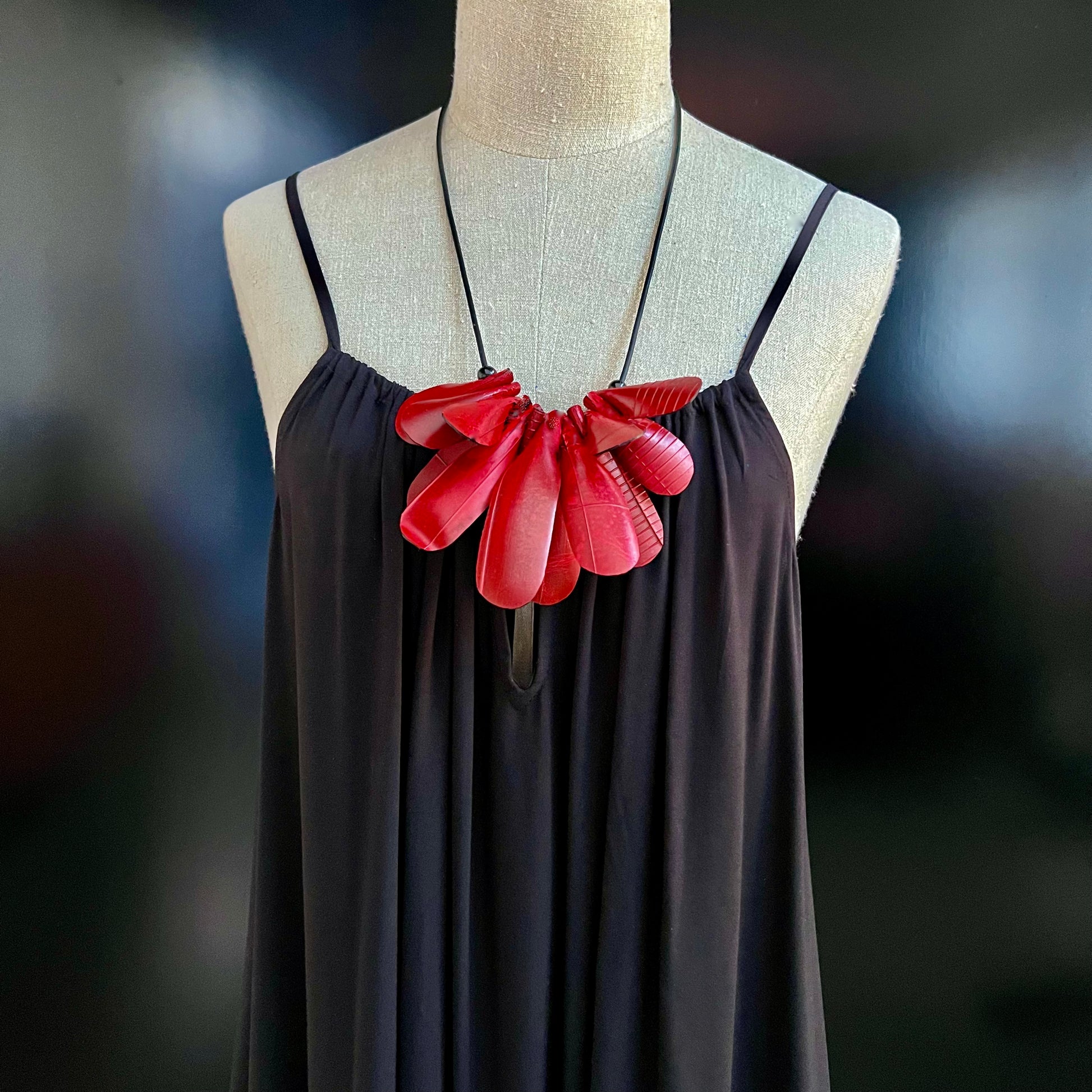 A mannequin wears a red painted rubber necklace