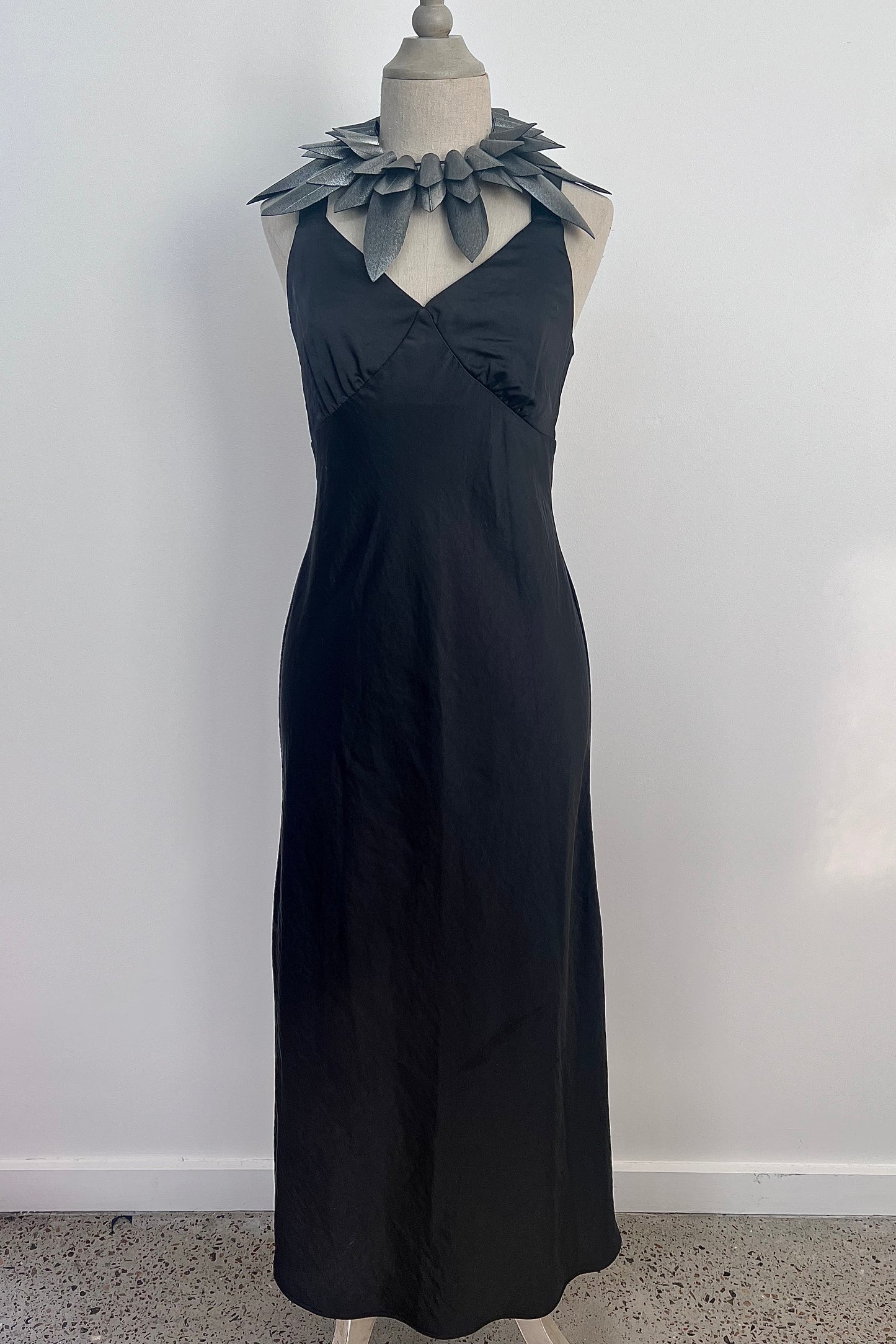 A mannequin wears a statement necklace of pointy silver rubber