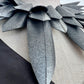 Close up of a pointy silver collar  necklace against a white background