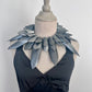 Mannequin wearing a black dress with a large, pointy silver collar against a white background
