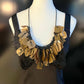 A mannequin wears a necklace made from bronze coloured recycled plastic