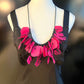 A mannequin wears a necklace made from pink coloured recycled plastic