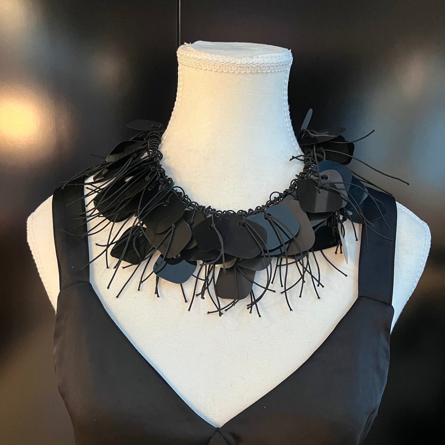 A mannequin wears a black plastic necklace made from x-rays as a choker