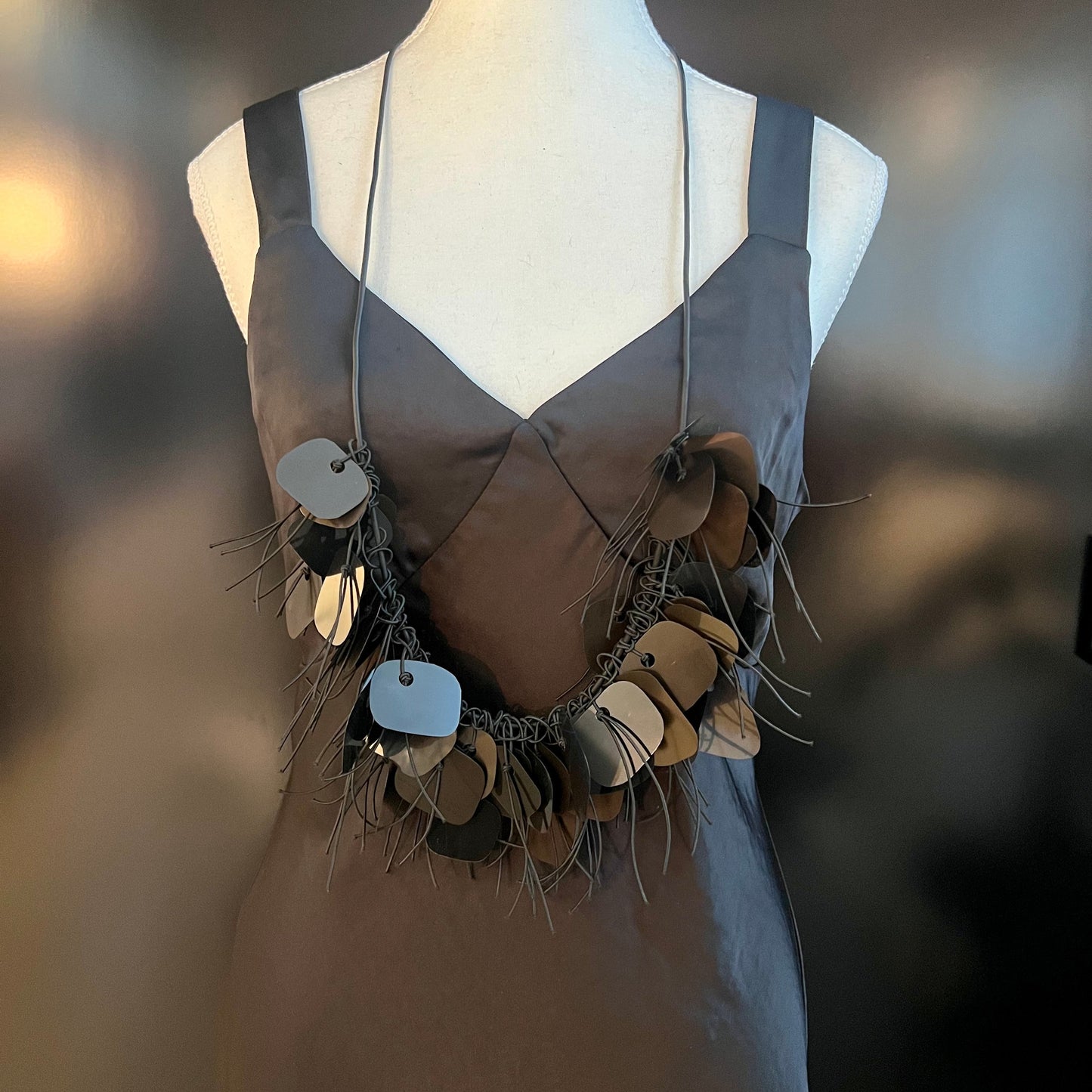 A mannequin wears a black plastic necklace made from x-rays