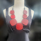 A mannequin wears a chunky red necklace worn chest length