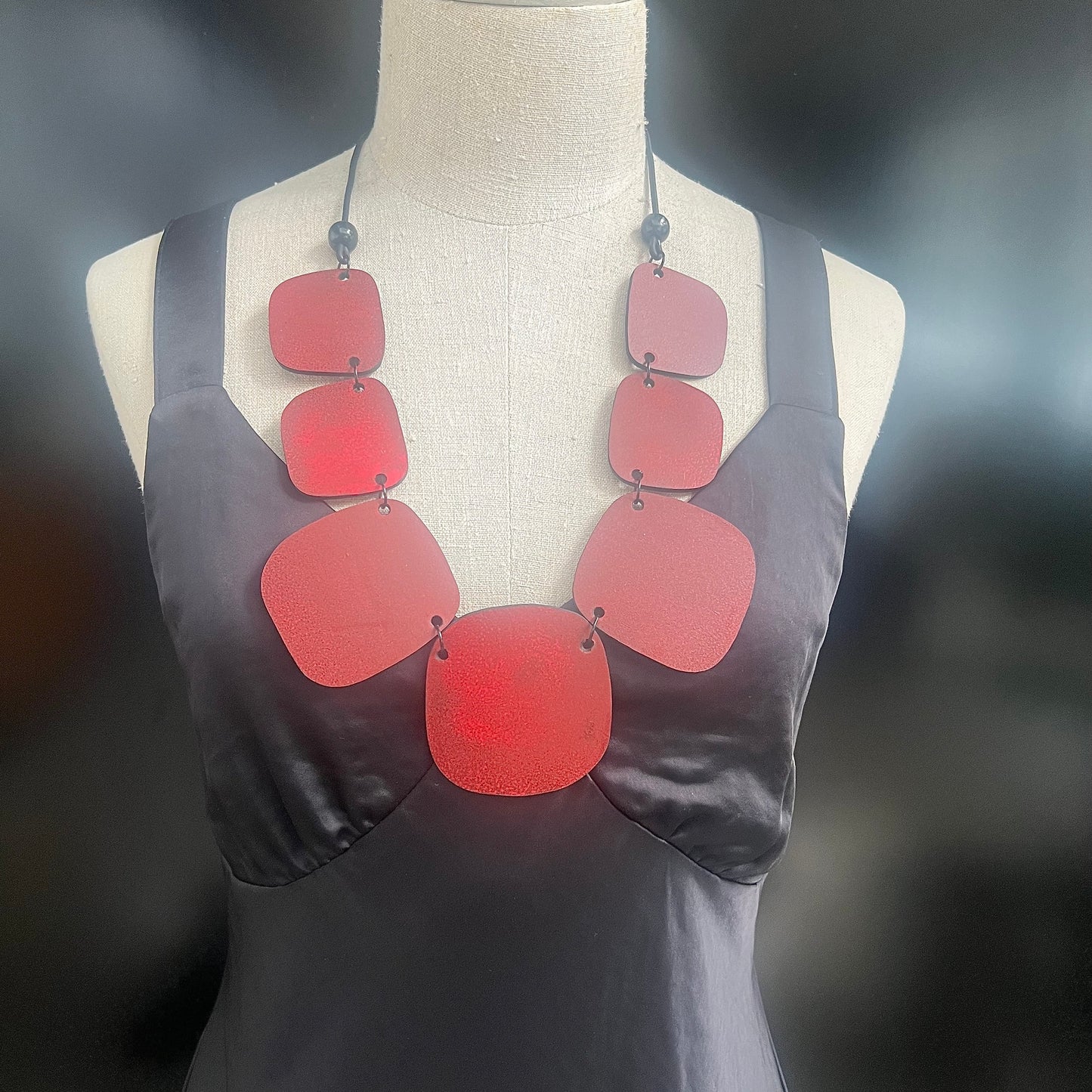 A mannequin wears a chunky red necklace worn chest length