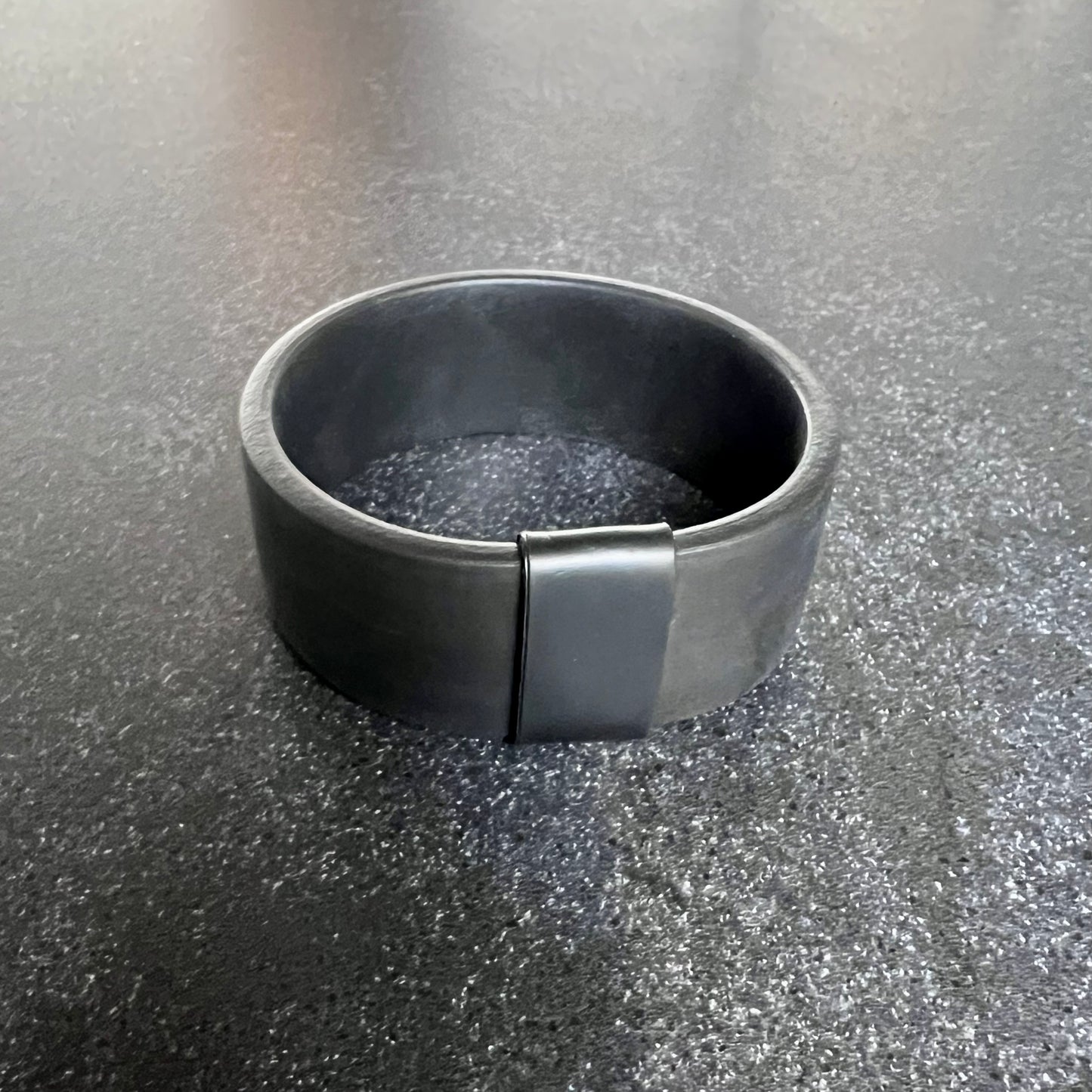 A rubber cuff bangle with a strip of black rubber