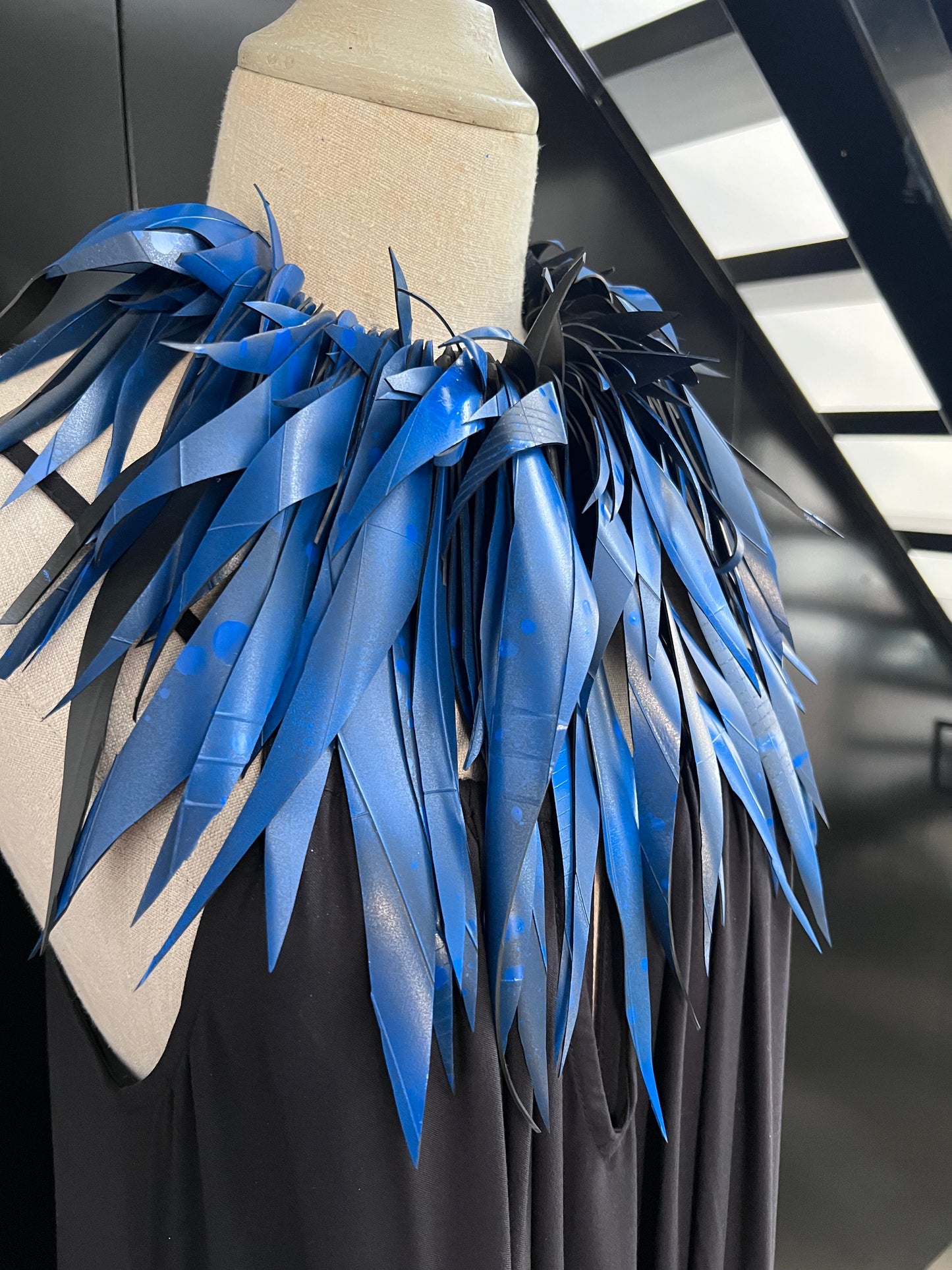 A mannequin wears a large blue rubber necklace