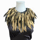 Gold feathery necklace collar on a mannequin against a white background